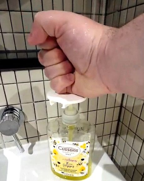 A closed fist pressing down on the disc fitted to the top of a soap pump